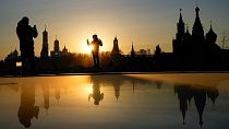 A woman poses for a photo during sunset over the Kremlin at Zaryadye Park near Red Square in Moscow, Russia, Wednesday, March 23, 2022.