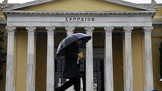 Πεζός με ομπρέλα για να προστατευθεί από την βροχή στο Ζάππειο Μέγαρο στην Αθήνα