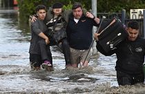 شبان يحملون سيدة في ملبورن حيث عمت الفيضانات عددا من الولايات في أستراليا