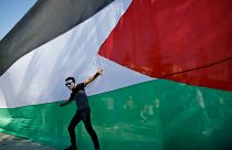 شاب فلسطيني يقف أمام علمه الوطني خلال احتفالات في مدينة غزة. 2017/10/12