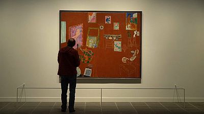 A visitor looking at 'The Red Studio' by Henri Matisse, 1911, in Denmark's National Gallery.