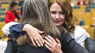 Australia's Laurie Marsden, former fashion model, gets a hug at the Stop Violence Against Women conference at the European Parliament in Brussels, Wednesday, Oct 12, 2022.
