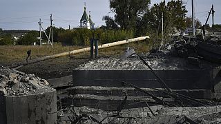 Un homme marche sur un gazoduc au-dessus d'un pont détruit après un bombardement à Bakhmut, en Ukraine - 22.09.2022