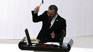 Opposition legislator Burak Erbay smashes a smart phone with a hammer while addressing parliament