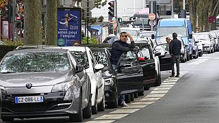 A man stands by his car as he waits to reach a petrol station in Nanterre, France