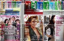 مجلة فوغ تتوسط عنواني صحيفتين أخرتين، تباع في كشك لبيع الصحف في نيويورك. 2010/03/08