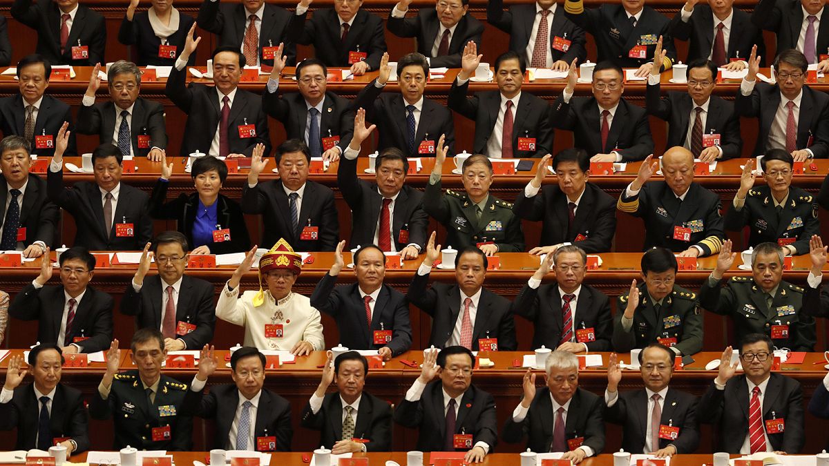 Delegates raise their hands to show approval of work reports during the closing ceremony for the 19th Party Congress at the Great Hall of the People in Beijing in October 2017