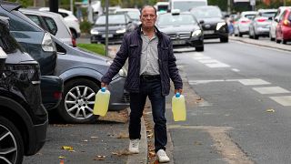 Kannában visz benzint egy férfi a Párizs melletti Nanterre-ben 2022. október 14-én
