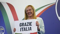 زعيمة حزب اليمين المتطرف "فراتيللي ديتاليا"، جيورجيا ميلوني تعرض لافتة مكتوب عليها باللغة الإيطالية "شكراً إيطاليا" في المقر الانتخابي لحزبها في روما، 26 سبتمبر، 2022