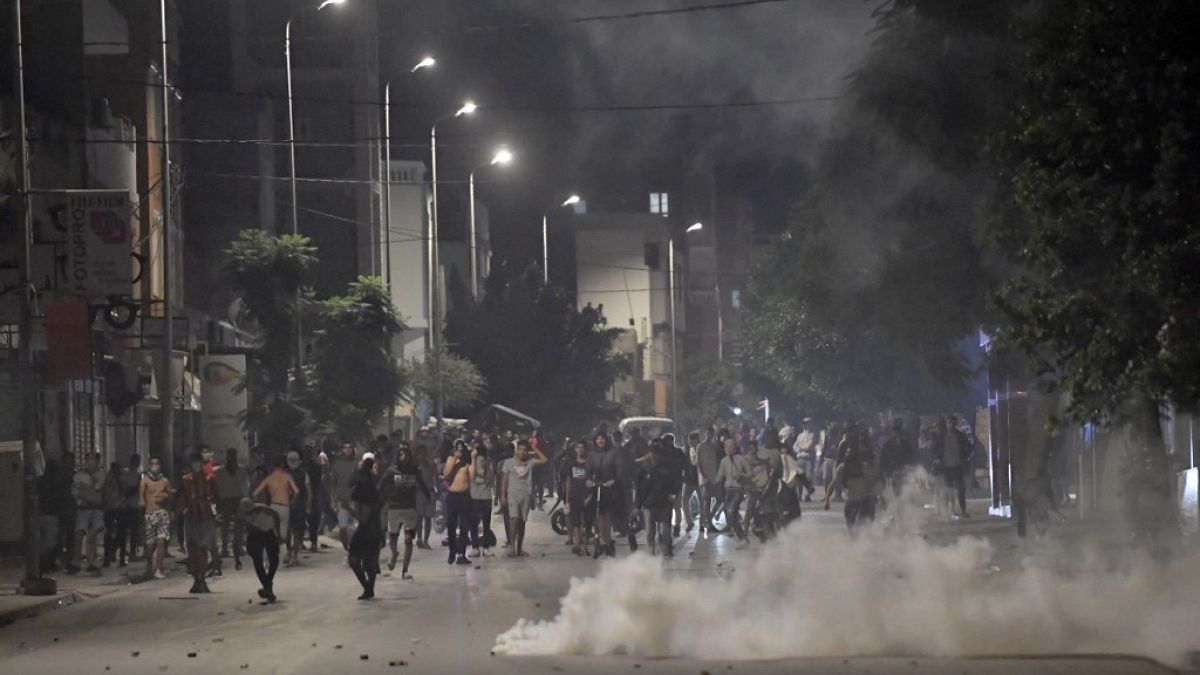 يحمي المتظاهرون أنفسهم من الغاز المسيل للدموع في حي التضامن غرب العاصمة تونس، 14 أكتوبر 2022 ،