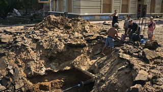 Residentes locales toman agua de un suministro restaurado en un cráter tras el impacto de una bomba aérea en Bakhmut, región de Donetsk, Ucrania, el 31 de agosto de 2022