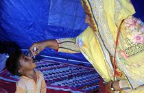 A health worker administers a polio vaccine to a child at a camp in Hyderabad, Pakistan, Tuesday, Sept. 6, 2022.