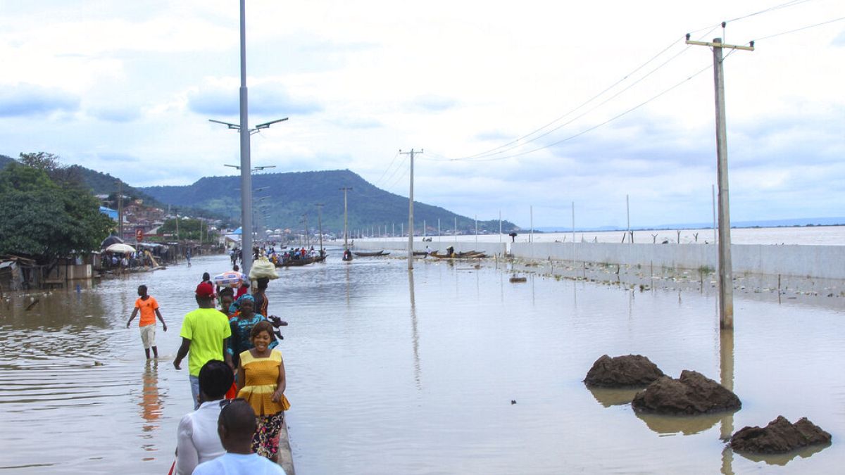 Άνθρωποι περιπλανιούνται στους πλημμυρισμένους δρόμους της πόλης Κόγκι στη Νιγηρία