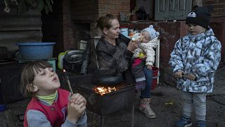 Ukrán nő eteti 9 hónapos gyermekét az ukrajnai Iziumban