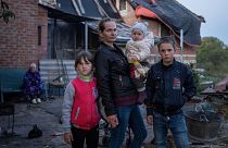 Маргарита Ткаченко с детьми Софией, Вероникой и Никитой перед своим разрушенным домом в городе Изюм, Украина. Сентябрь 2022 г.