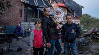 Маргарита Ткаченко с детьми Софией, Вероникой и Никитой перед своим разрушенным домом в городе Изюм, Украина. Сентябрь 2022 г.
