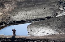 A couple stands on what was an ancient packhorse bridge exposed by low water levels at Baitings Reservoir in Yorkshire, England, Aug. 12, 2022.