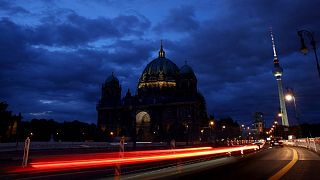 The Television Tower glows at dusk next to the Protestant Berlin Cathedral with a reduced lighting to save energy due to Russia's invasion of Ukraine in Berlin
