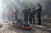 Des policiers ukrainiens se tiennent à côté du corps d'un homme tué après qu'un drone ait tiré sur des bâtiments à Kyiv, en Ukraine, lundi 17 octobre 2022.