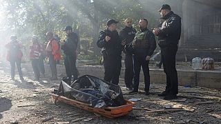 Agentes de policía junto al cuerpo de un hombre muerto tras el disparo de un dron contra edificios en Kiev, Ucrania, el lunes 17 de octubre de 2022.