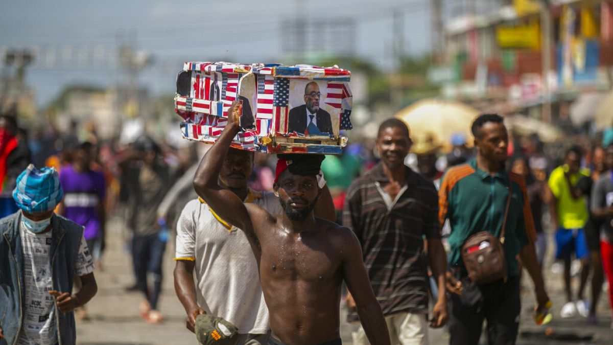 Des manifestants portent un faux cercueil à l'effigie du Premier ministre lors d'une manifestation à Port-au-Prince, Haïti, lundi 17 octobre 2022