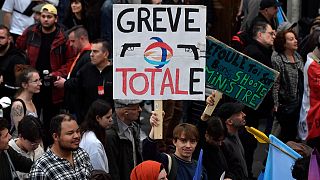 A protester holds a placard reading 'Total strike' -a play on the French energy giant TotalEnergies- during a rally in Paris on October 16, 2022.