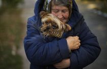 Una mujer calienta a su perro en Kivsharivka, Ucrania, el 16 de octubre de 2022.