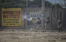 شرطي يطلق الغاز المسيل للدموع على المتظاهرين خلال احتجاجات في بورت أو برنس هايتي