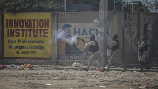 شرطي يطلق الغاز المسيل للدموع على المتظاهرين خلال احتجاجات في بورت أو برنس هايتي