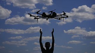 A person releases a drone. 