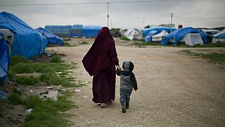Σύζυγος Γάλλου τζιχαντιστή περπατάει με το παιδί της σε κέντρο κράτησης στη Συρία