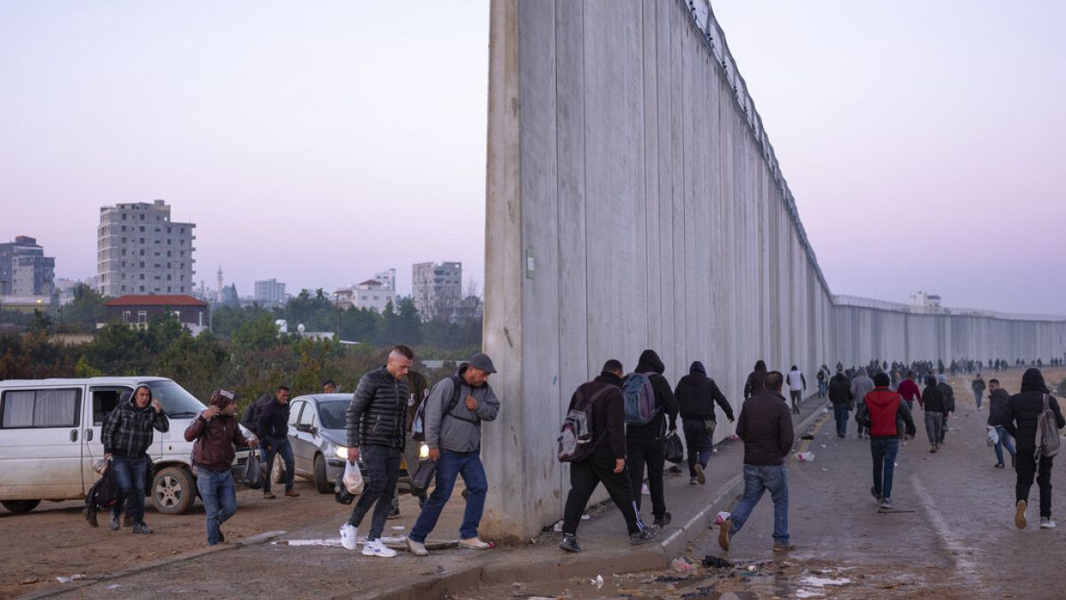 Palestinos cruzan a Israel desde Cisjordania a través de una abertura en la barrera de separación israelí en la ciudad cisjordana de Qalqilya