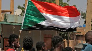 متظاهرون يلوحون بالعلم الوطني السوداني خلال مظاهرة مناهضة للحكومة للمطالبة بالعودة إلى الحكم المدني في العاصمة السودانية الخرطوم. 2022/10/13