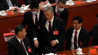 L'ex presidente cinese scortato fuori dalla cerimonia di chiusura.