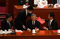 Former Chinese President Hu Jintao, front row second from right, talks to his predecessor as party leader Xi Jinping, right.