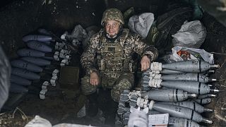 A Ukrainian soldier sits in shelter as he prepare fire the Russian positions with the mortar in Bakhmut, 21 October 2022