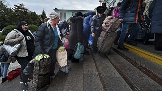 Departees from Kherson gather upon their arrival at the railway station in Dzhankoi, Crimea, 21 October 2022