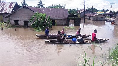 People transport cassava in a canoes along flooded residential streets after a heavy downpour In Bayelsa, Nigeria