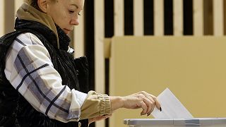 A woman casts her ballot for a presidential election at a poling station in Ljubljana, 23 October 2022