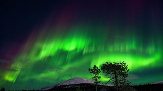 An aurora borealis, also known as Northern Lights, illuminates the night sky above the Kellostapuli Fell in Kolari, Finnish Lapland, early on 15 January 2022.