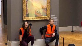 Activists glued themselves to the wall underneath Monet’s work