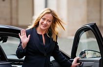 Italian Premier Giorgia Meloni waves to cameras as she leaves after swearing in at Quirinal presidential palace, Saturday, Oct. 22, 2022.