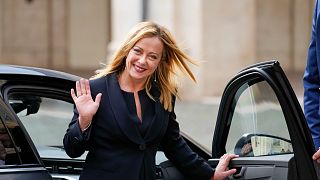 Italian Premier Giorgia Meloni waves to cameras as she leaves after swearing in at Quirinal presidential palace, Saturday, Oct. 22, 2022.