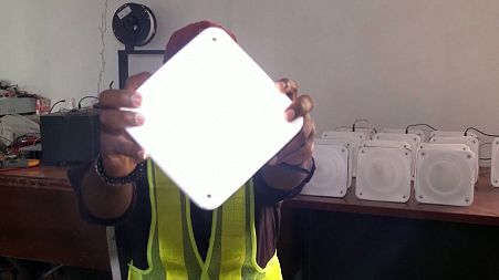 Dozie Igweilo holds a QuadLoop solar lamp