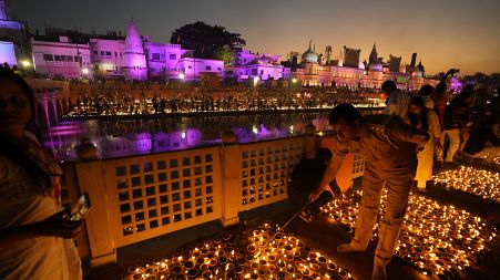 People light lamps on the banks of the river Saryu in Ayodhya, India