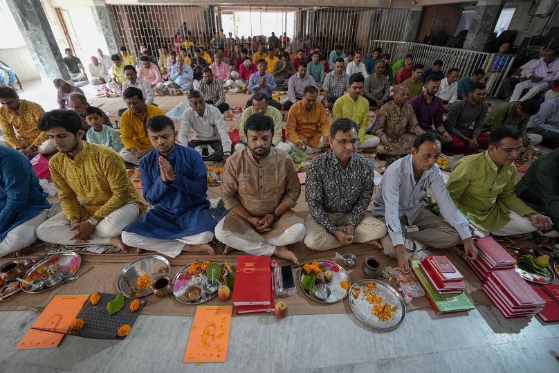 Indian traders perform rituals during Chopda Pujan, a prayer ceremony dedicated to the worship of account books, on the occasion of Diwali