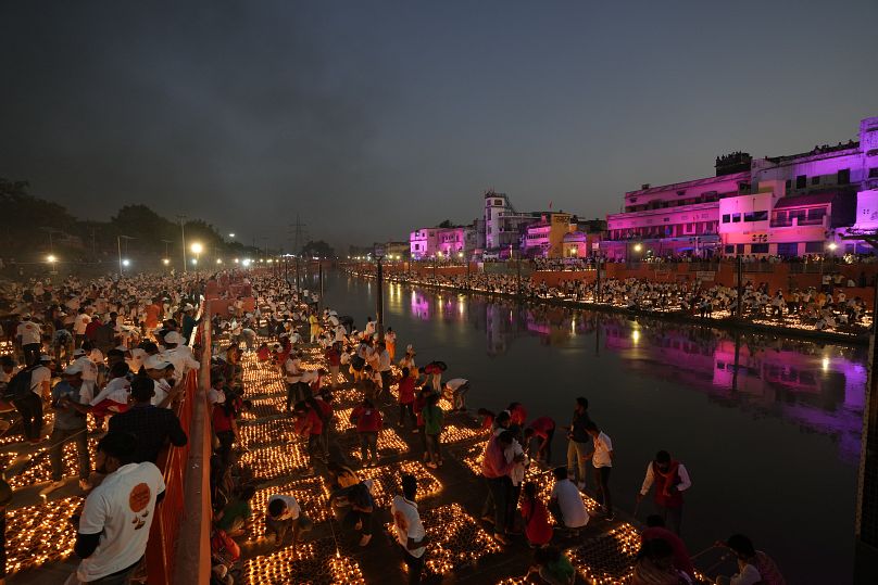 People light lamps on the banks of the river Saryu in Ayodhya, India