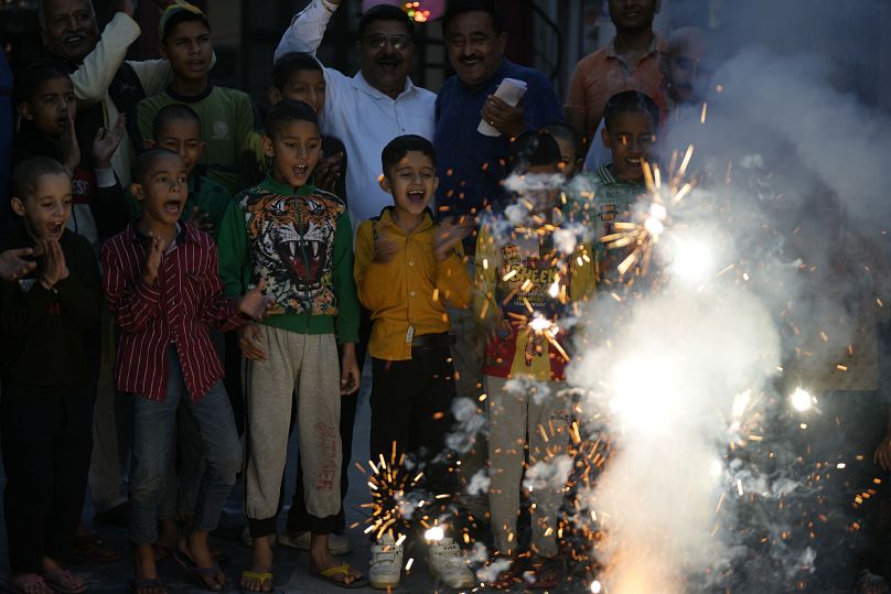 Children watch firecrackers being lit on the eve of Diwali at an orphanage in Jammu, India,
