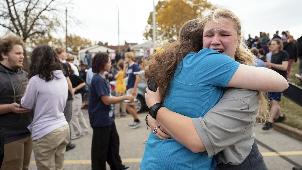 People embrace in the Schnucks Arsenal parking lot following a shooting at Central Visual Performing Arts High School in St. Louis on Monday, 24 October 2022.