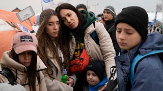 Refugees wait in a queue, after fleeing the war from neighbouring Ukraine at the border crossing in Medyka, southeastern Poland, on Tuesday, March 29, 2022